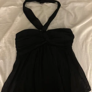 Svart topp från Nelly - Snygg svart topp från Nelly med halterneck. Man kan knyta på olika sätt, se första och andra bilden. Perfekt för en kväll ute eller en speciell tillställning. Köpte för 350 på nellys hemsida💞