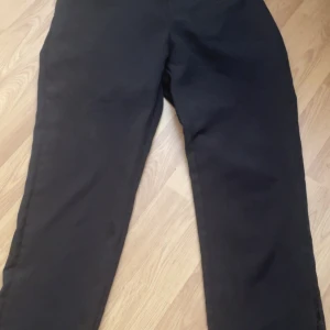 Svarta byxor - Snygga svarta byxor med en klassisk design. De har en rak passform och är perfekta för en stilren look. Byxorna är tillverkade i ett bekvämt material som passar för olika tillfällen.