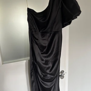 Svart balklänning - Svart one-shoulder balklänning med slits och puffärm, använd en gång. 