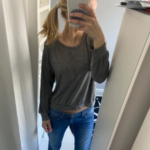 Grå tröja med rund hals - Säljer en stilren grå tröja med rund hals och långa ärmar. Tröjan har en bekväm passform och är lätt att matcha med olika outfits. Man kan ha den för sig eller som en tunn tjocktröja :). 