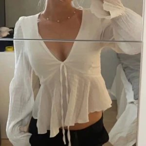 Vit blus  - Säljer denna söta blusen med knytning framtill. Den är som ny! Lappen är bortklippt men den passar någon som har storlek S