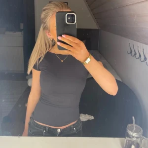 Mörkgrå topp från Gina Tricot - Säljer en stilren mörkgrå topp från Gina Tricot. Toppen har en öppen rygg. Perfekt för en trendig look.