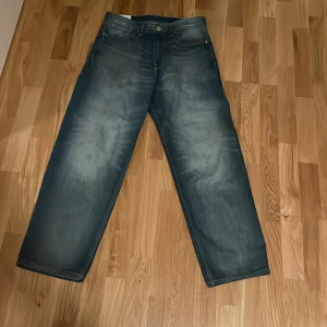 Blå jeans från H&M - Säljer ett par blå jeans från H&M med en loose fit. De har en klassisk femficksdesign och är tillverkade i ett slitstarkt denimtyg. Perfekta för en avslappnad stil. Skriv vid minsta frågor.