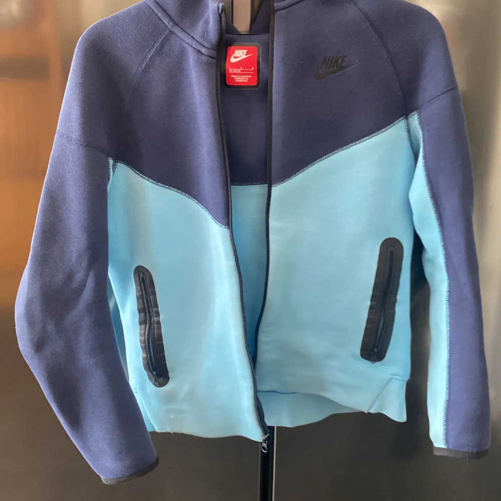 Säljer en snygg hoodie från Nike i en cool kombination av mörkblått och ljusblått. Jackan har en dragkedja framtill och praktiska fickor med dragkedjor. Perfekt för en sportig look!. Takit.
