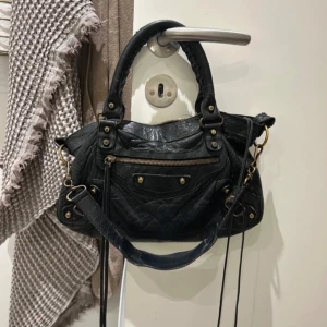 Balenciaga first bag - Kikar intresse för min svarta balen iaga first bag! Super fin den har defekt på ena handtaget och ett litet hål inne men annars bra! Saknar spegel