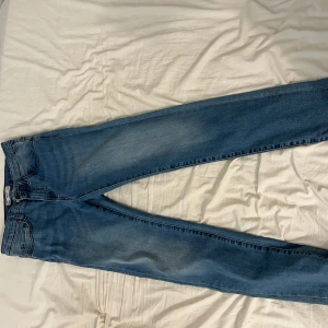 Blå slim jeans från Cubus - Snygga blå slim jeans från Cubus i en klassisk denimstil. De har en dragkedja och knapp framtill samt hällor för bälte. Perfekta för en stilren look.