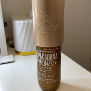 Sol de Janeiro Copacabana Bronze Glow Oil - Glowmotions Copacabana Bronze Glow Oil från Sol de Janeiro ger en skimrande bronzig finish till både kropp och ansikte. Oljan har en varm, gyllenbrun ton med massor av glow och kommer i en snygg flaska med guldlock. Perfekt för att boosta lystern.