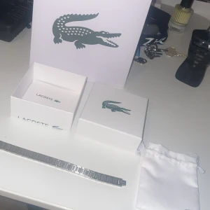 Silverfärgad klocka från Lacoste - Lacoste armband knappt andvänd helt ny med all original packetering. Man kan ändra storlekarna. Köpt från lacoste.se för ca 1000 kronor. Är ute för endast 799. Priset kan diskuteras vid snabb affär. 