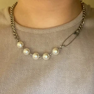 Halsband med pärlor och säkerhetsnål - Unikt halsband med en kombination av silverkedja och vita pärlor som liknar Maria Nilsdotter.