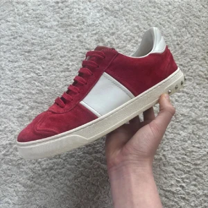 Valentino flycrew - Snygga Valentino flycrew sneakers i röd mocka med vita skinnpaneler och coola nitar på hälen. Yttersulan har ett unikt camouflagemönster. Perfekta för dig som vill sticka ut med stil. Storlek 40 men passar 41. Skick 8,5/10 alla nitar kvar