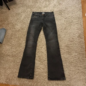 Bootcut jeans - Mörkgråa bootcut jeans med broderade rosetter på bakfickorna, använda fåtalgånger så i väldigt bra skick🩵