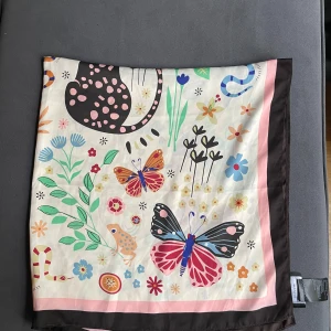 Färgglad blommig scarf & Other Stories - Knappt använd!Snygg fyrkantig scarf från & Other Stories med blommigt och djurinspirerat mönster. Färgerna är vit, rosa, brun, blå, grön, röd och orange. Halsduken har en bred brun kant och är tillverkad i ett tunt material 