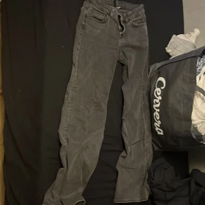 Grå bootcut jeans från H&M Divided - Säljer ett par gråa bootcut jeans från H&M Divided i storlek 36. Jeansen har klassisk femficksdesign, normal passform över låren och utsvängda ben. Tillverkade i mjukt bomullsmaterial med en snygg tvättad look.