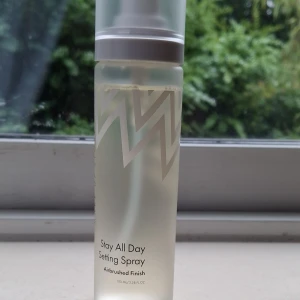 Stay All Day Setting Spray 100 ml -   Är använd lite men är ändå mycket kvar Stay All Day Setting Spray med airbrushed finish i en genomskinlig plastflaska med vitt mönster och frostad vit kork. Ger en fräsch känsla och håller sminket på plats hela dagen. Perfekt för dig som vill ha en naturlig look som sitter länge.