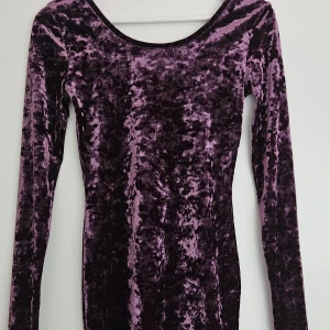 Lila långärmad miniklänning i sammet - Figurnära miniklänning i krossad sammet från H&M Divided. Tight passform med stretchigt material & rundad halsringning i färg lila. Väldigt fint skick, använd några få gånger Storlek XS.