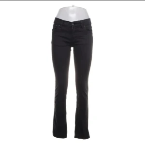 Svarta bootcut jeans - Snygga svarta jeans med bootcut passform och klassisk femficksdesign. Jeansen har normal midja och är tillverkade i ett stretchigt bomullsmaterial som sitter skönt hela dagen. Perfekta för dig som gillar en tidlös look med lite utsvängda ben. Köpte för 700 knappt använda.