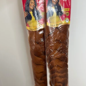 Lush Hair Wow Braids Ginger (Två paket) - Två paket Lush Hair Wow Braids i färgen Ginger. Syntetiskt hår, extra lätt och supermjukt med en glansig finish. Perfekt för att skapa långa, fylliga flätor. Varje paket innehåller 230g och längden är 82 tum. Färgen är en varm kopparbrun ton.