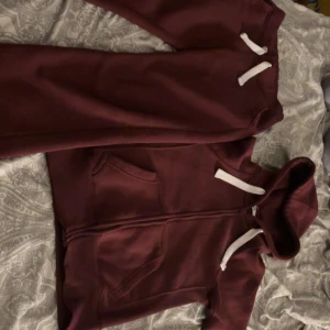 Vinröd hoodie från russemerch🥰 - Mysig vinröd hoodie med vit snörning och dragkedja framtill. Tröjanr från russemerch och är i superbra skick! Storlek Xs och knappt använd🥰