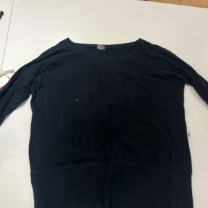 Svart långärmad tröja S/M - En basic svart långärmad tröja i enkel design. Tröjan har rund halsringning och är tillverkad i ett mjukt material, perfekt för lager-på-lager eller chill dagar. Passar dig som gillar minimalistisk stil.