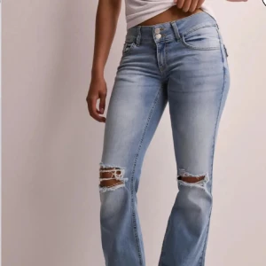 Ljusblå bootcut jeans med slitningar - Säljer mina helt oanvända jeans pågrund av att de är för småa. Snygga ljusblå jeans med bootcut passform och slitna detaljer vid knäna. Jag är öppen till att byta ut jeansen till en storlek större också.🩷