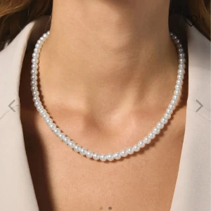 Klassiskt pärlhalsband i vitt - Snyggt och tidlöst halsband med vita pärlor som sitter tätt och ger en elegant look. Perfekt för dig som gillar stilrena smycken med en lyxig känsla. Rund form på pärlorna och diskret design som passar till många outfits.