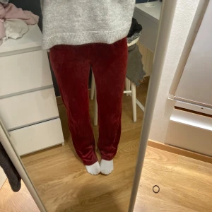 Vinröda mjukisbyxor med snörning - Säljer ett par vinröda mjukisbyxor i mjuk sammet med rak passform. Byxorna har resår i midjan och två metallhål för snörning. Perfekta för chill dagar hemma eller när du vill vara extra comfy. Saknar snören!!!!