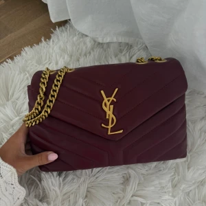 Ysl väska - Såå fin vinröd ysl väska i skin med guldiga detaljer✨Köpt helt ny av en tjej på Plick men kommer inte till användning. Den är helt oanvänd och har inga defekter eller tecken på användning. Dock ingen aning om den är äkta. Skriv för fler frågor!!💖  