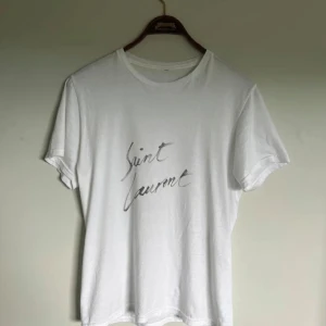 Saint Laurent t shirt - Riktigt fet och eftertraktad Saint Laurent t shirt i helt nytt skick 10/10! Är lite osäker på äktheten så därför är priset just nu på 599kr! nypris runt 4000kr. Storlek S. Tveka inte med att ställa frågor!