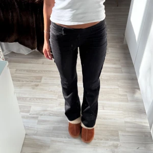 Svarta bootcut byxor med låg midja - Snygga svarta byxor med bootcut-snitt och låg midja. Från Åhléns i storlek 36. Saknar en knapp i midjan som fungerar som ett extra spänne. Den har två andra spännen i midjebandet så detta påverkar ej så mycket! 