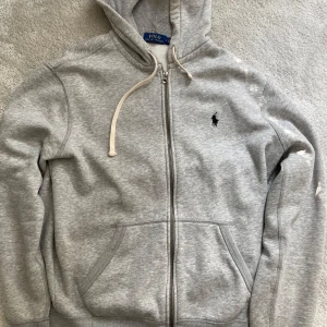 Ralph lauren zip hoodie - Säljer denna ass feta Ralph Lauren zip hoodie. Tröjan är i använt skick. Tröjan säljs så billigt pga dragkedjan är lite strulig ibland, men den går absolut att använda. Inga defekter förutom dom som vissas i bilderna. Vid minsta fundering är bara att skriva mvh Alexander 