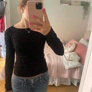 Svart långärmad topp Gina Tricot - Svart långärmad topp från Gina Tricot med ribbad struktur och vågiga kanter längs halsringning och sömmar. Modellen är tight men stretchigt och funkar för alla tillfällen❤️