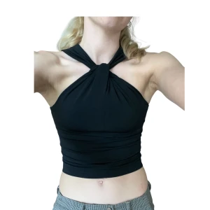 Svart croppad halterneck topp - Kort svart top med halterneck (crop top). Dubbelt lager tyg framtill och baktill.  Från French connection Storlek: 4 (uk) - passar ungefär som en stretchigt tyg, skulle säga att den passar upp till S  I jättebra skick! Nästan inga tecken på användning