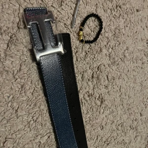 Mörkblått H bälte  - Säljer mitt herrmesbälte 115cm. Helt nytt armband ingår. 