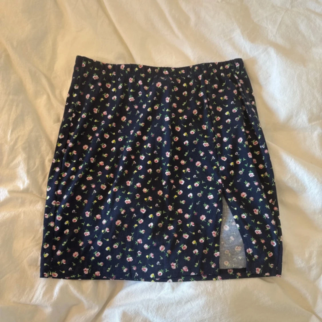 Blommig mörkblå kortkjol med slits