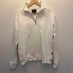 Half zip - Säljer en stilren vit långärmad tröja från Bondelid i storlek S. Tröjan har en hög krage med half zip-dragkedja och är gjord i mjuk bomull. Perfekt för chill dagar eller när du vill ha en clean look. Klassisk design utan mönster eller extra detaljer. Inga defekter.