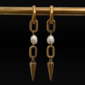 Guldiga örhängen med pärlor och spikes - Unika örhängen i guldton med rektangulära länkar, vita pärlor och spetsiga spikes längst ner. Perfekt för dig som vill sticka ut med en cool och elegant vibe. Snyggt hängande design som ger extra edge till din look.