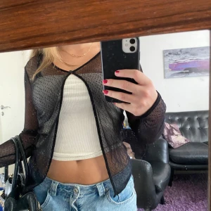 Svart blus med prickar KappAhl - Säljer en transparent svart meshblus från KappAhl i storlek 38-40. Blusen har lång ärm, v-ringning och små svarta prickar i tyget. Perfekt för lager-på-lager och att styla med coola accessoarer. Den är väldigt tunn och transparent. Köpt för ett par år sedan men använd ett fåtal gånger.