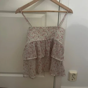 Blommig volangtop från Gina Tricot - Supersöt blommig topp från Gina Tricot med volanger och smock upptill. 