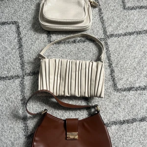 Paketpris!! Tre snygga axelväskor i beige och brunt - Säljer tre trendiga axelväskor! Den beiga väskan längst har dessutom ett längre band! Går och köpa var för sig också!! 200 kr för alla tre