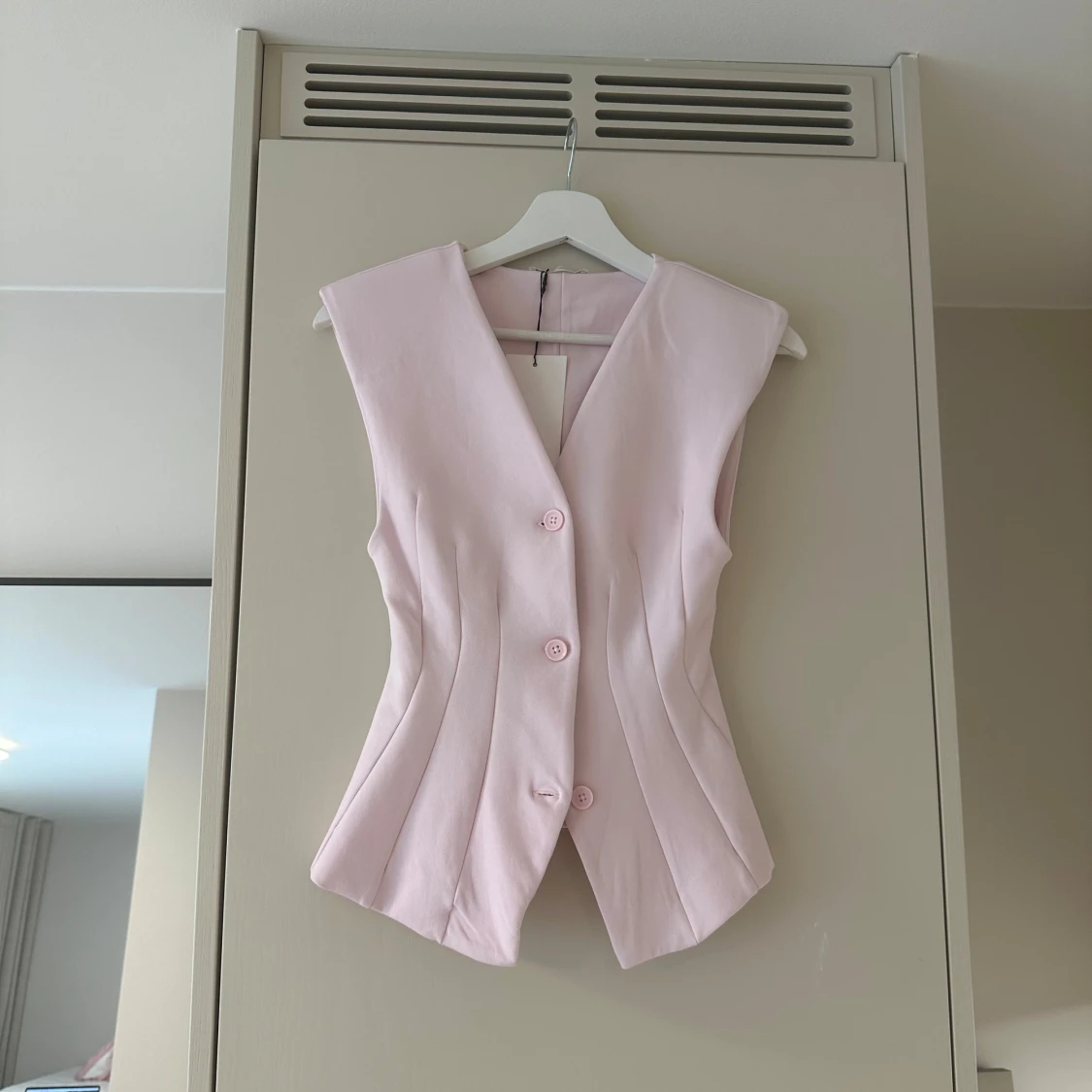 Ljusrosa figursydd väst med knappar - 1