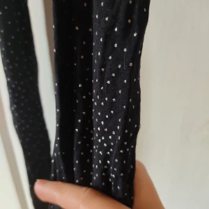 Glittriga strumpbyxor - Ett par svarta strumpbyxor med små glittriga silverprickar över benen. Prickarna är sitter tätats längst ner och avtar då de går upp för benen. De har inte använts mycket och har inga hål alls. Det står inte storlek men det är strumpbyxor så. Vem vet.