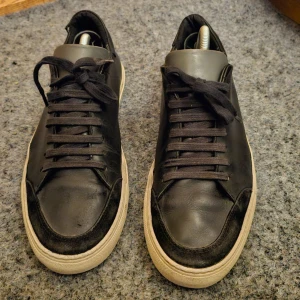 Axel Arigato, Clean 90 - Märke: Axel Arigato, Clean 90 Storlek: 42 Skick: 7/10. Begagnade i fint skick. Väl omhändertagna. Har mycket kvar att ge till nästa ägare. Liten lätt defekt högst upp på hälkapporna på båda skor, samt ytterst liten spricka vid gångveck på sidan av sulan på ena skon, finns bilder separat. Har försökt vara så tydlig och informativ det går via text och bilder. Vänligen se bilder och skapa er en egen uppfattning kring skick, slitage på sulorna etc.