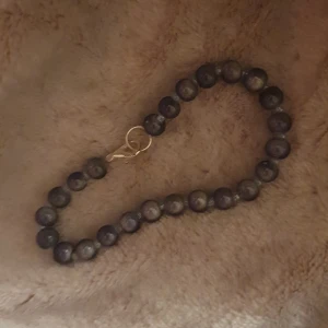 Blått pärlarmband med silverlås - Snyggt armband med runda blå pärlor och ett stilrent silverfärgat lås. Pärlorna har en mörkblå ton och är trädda på en tunn tråd. Perfekt för dig som gillar enkla men coola accessoarer.