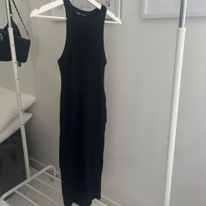 Svart ribbad klänning - Svart klänning utan armar i ribbat material, perfekt till vardags 🤩95% bomull. Använd fåtal gånger, jättefint skick. Skriv meddelande vid frågor/fler bilder 🩷