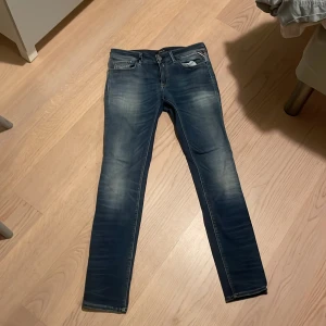 Blå jeans från Replay - Snygga blå jeans från Replay med en klassisk femficksdesign och dragkedja. De har en lätt tvättad look som ger en avslappnad stil. Perfekta för en casual outfit.