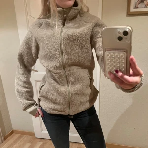 Fleecejacka - Beige fleecejacka! Mysig jacka som jag isånnafall skulle rekomendera att använda under sommar/vår/höst? Kontakta för frågor 💓OBS jag har vikt in kanten där nere på jackan där bak vid rumpan eftersom jag föredrar kortare jackor men om man föredrar längre är det bara att dra ut. 