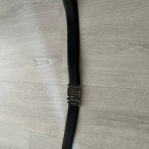 Svart bälte från Amiri - Svart Amiri bälte med ett spänne i guld. Tillverkat i skinn och har flera hål för justering. Skicket är 10/10 har används fåtal gånger