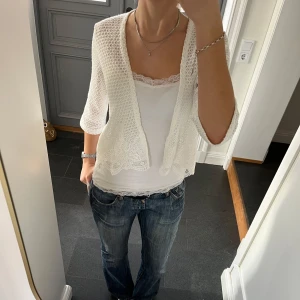 Vit stickad kofta med spets - Vit trekvartsärmad stickad kofta med spets från Yessica i fint skick. Kan inte hitta storlek men skulle säga S eller M. Använd gärna köp nu!