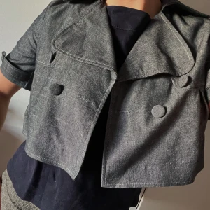 Grå croppad kappa - Snygg grå croppad kavaj med trekvarts ärmar och stora knappar. Perfekt nu till vår och sommar