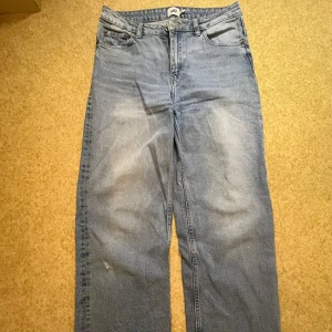 Blå jeansbyxor från Lager 157 - Säljer ett par klassiska blå jeansbyxor från Lager 157. De har en rak passform och är högmidjade med fickor och knappgylf. Perfekta för en avslappnad stil.